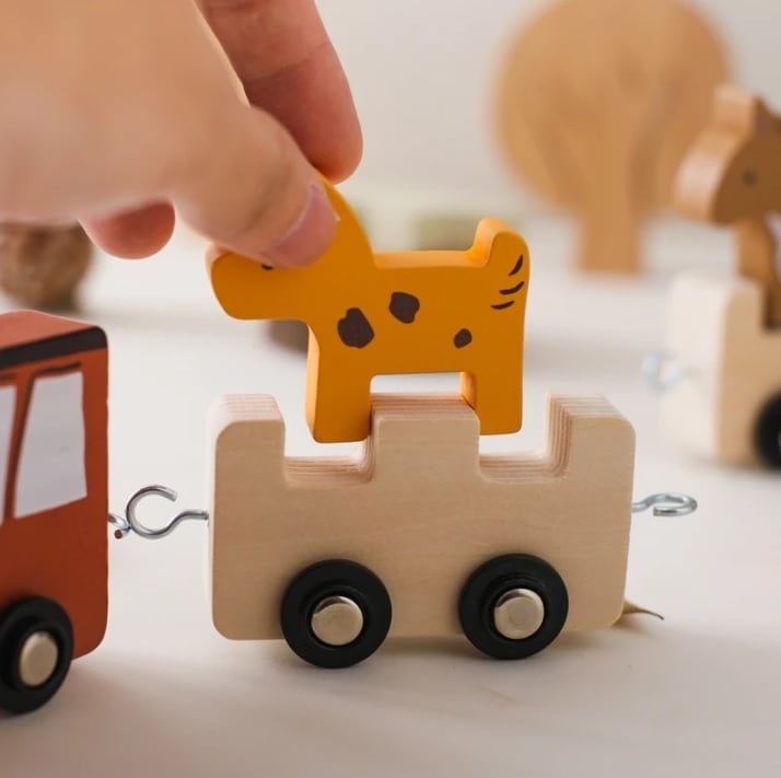 子どもが木製トレインを手で動かす様子